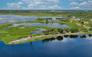 panorama of wetlands area at lakefront park with lighthouse on peninsula in lake tohopekaliga city of kissimmee feature