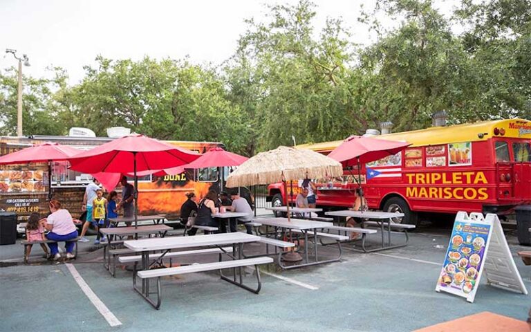 dining tables area outdoor between buses with food vendors at world food trucks kissimmee