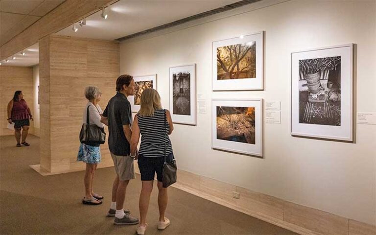 viewers admiring photography exhibit along wall at appleton museum of art ocala