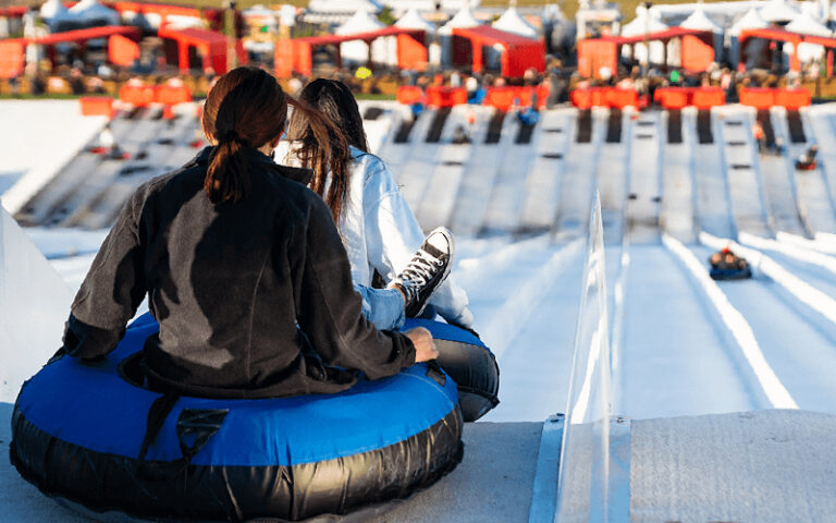 couple on double tube about to ride down slope at snowcat ridge dade city