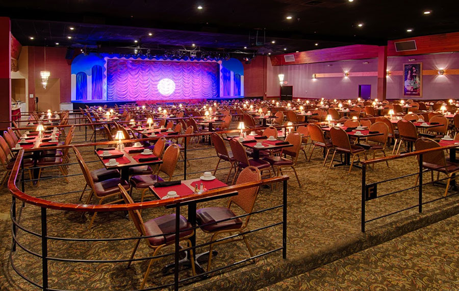 dining hall with tables and chairs and stage along back wall at broadway palm theatre fort myers