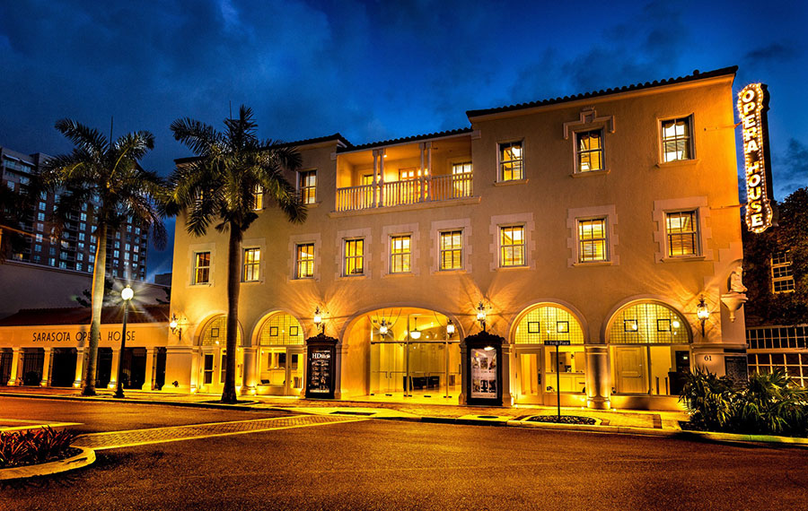 gold lighted building at night with palms street view at sarasota opera house