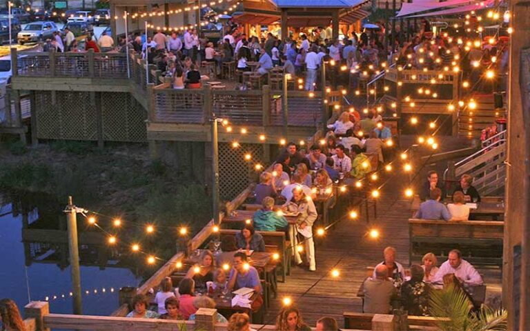 aerial view of crowded seating along dock at night at the fish house pensacola