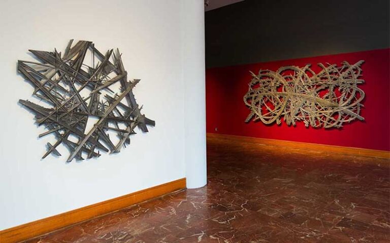 angled exhibit space with two wall mounted sculptures at polk museum of art lakeland