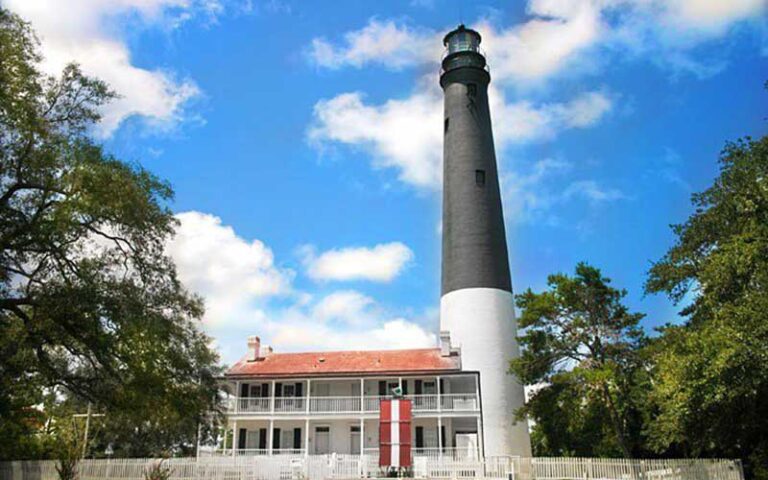 black and white lighthouse with historic building at pensacola lighthouse maritime museum