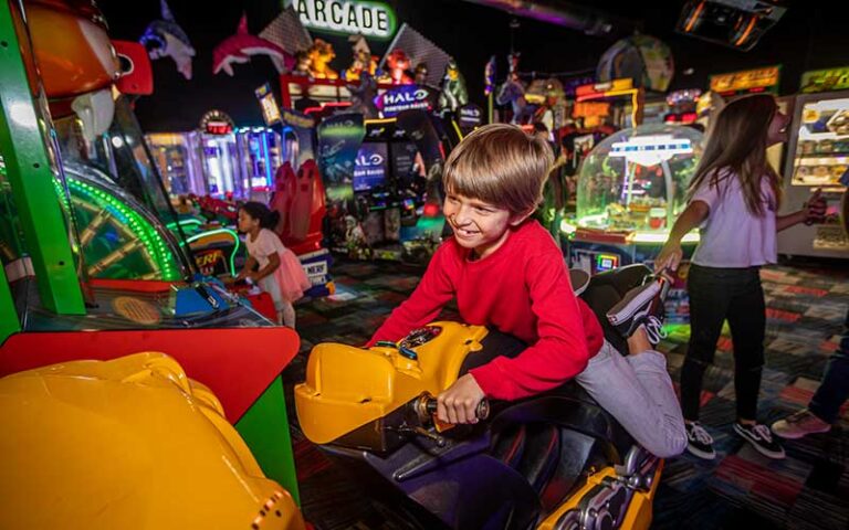 boy playing motorcycle race game at fast eddies fun center pensacola