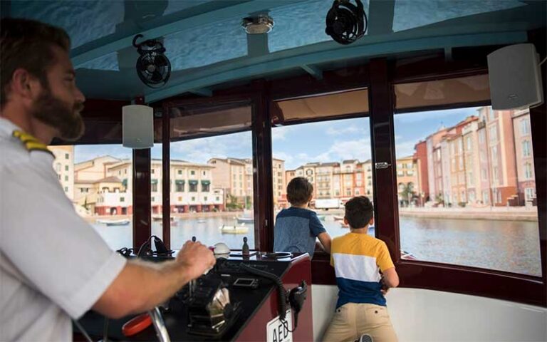 boys looking at hotel from boat window at loews portofino bay hotel universal orlando