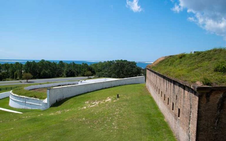 bricked fort wall on hillside with white wall below at historic fort barrancas pensacola