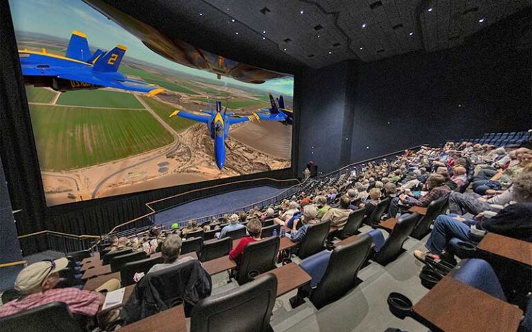 crowded movie theater with blue jets on screen at national naval aviation museum pensacola