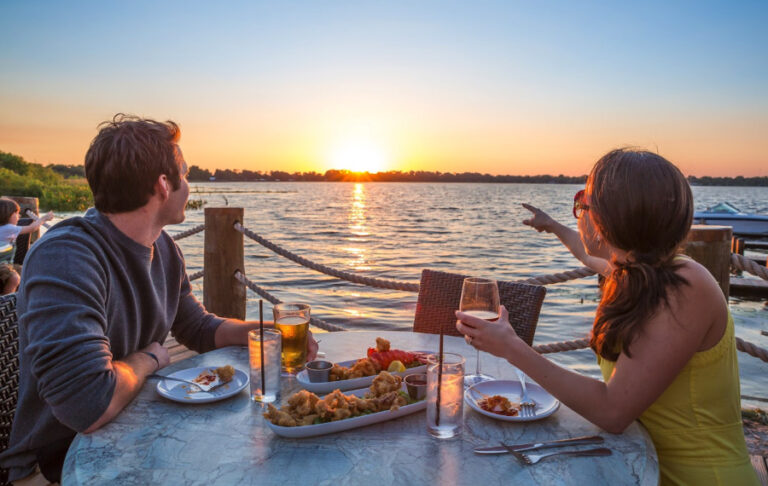 couple diners seated along dock with sunset over lake at harborside winter haven