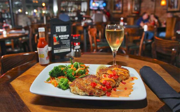 crab cakes entree with wine set on table at harrys seafood bar grille lakeland