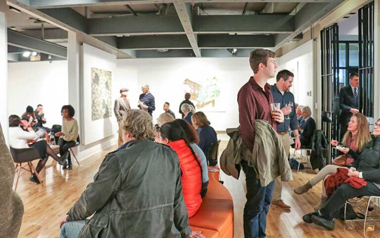 crowded event in exhibit room at pensacola museum of art