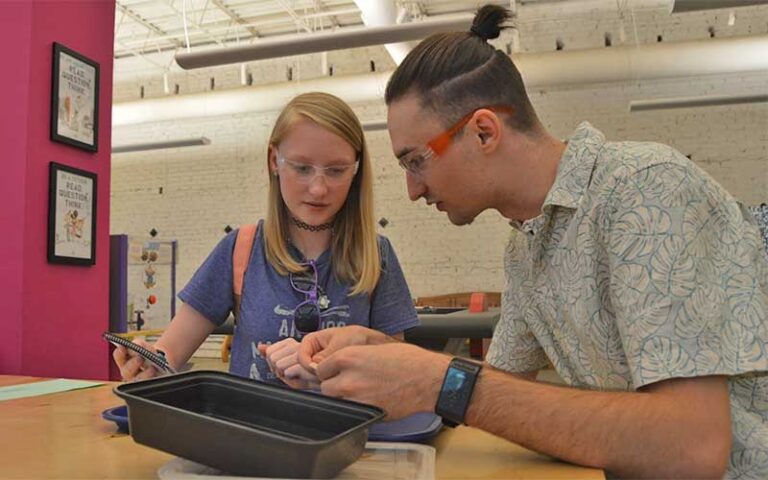 dad and daughter with safety glasses working at table at pensacola mess hall