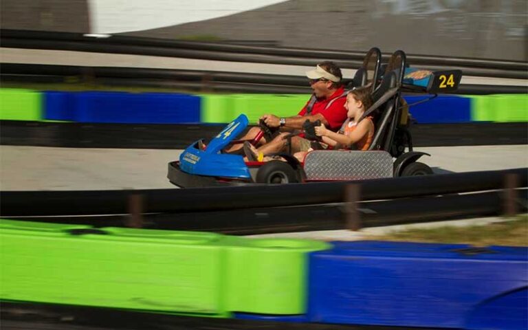 father and daughter racing two seater go kart on track at daytona beach boardwalk amusements