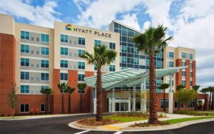 front exterior of hotel with cloudy sky at hyatt place pensacola airport