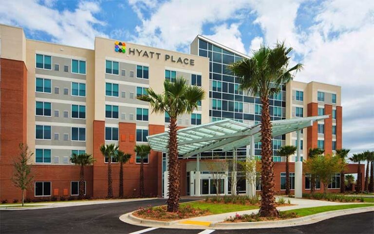front exterior of hotel with cloudy sky at hyatt place pensacola airport