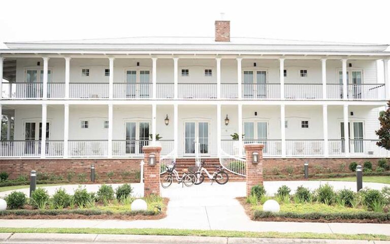 front exterior of two story hotel with bikes and entrance at oyster bay boutique hotel pensacola
