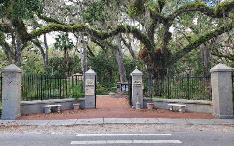 gate entrance to park with trees and wall fence at dunlawton sugar mill gardens port orange daytona beach