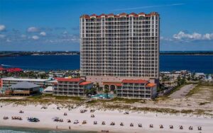 high rise hotel with beachfront and bay behind at beach club resort spa pensacola