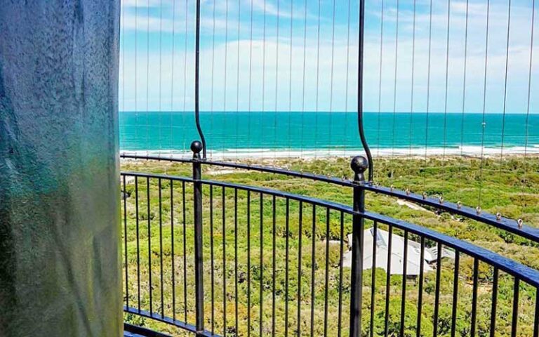 high view of beach and ocean with iron grate at ponce de leon inlet lighthouse museum daytona beach