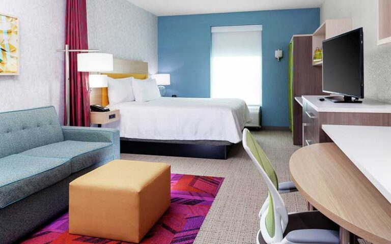 king bed suite with colorful accents at home2 suites by hilton orlando south park