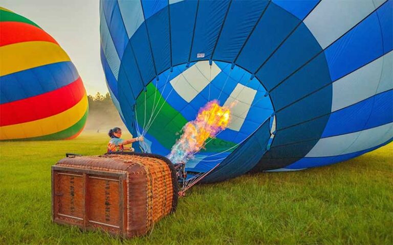 lady filling up hot air balloon in foggy field at air hound adventures davenport orlando