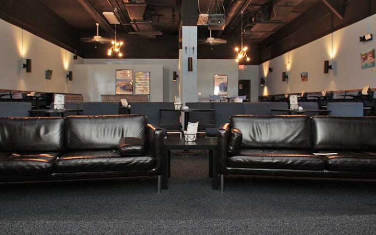 leather sofas and dining seating in theater room at cinematique theater daytona beach