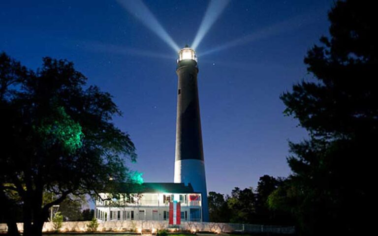 lighthouse at night with beams of light at pensacola lighthouse maritime museum
