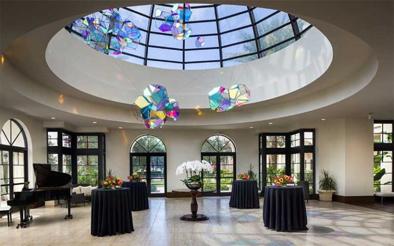 lobby with grand piano and stained glass pendants in atrium at the alfond inn at rollins winter park orlando