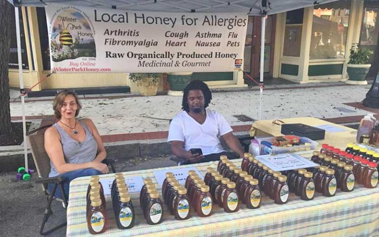local honey booth with vendors at lakeland downtown farmers curb market