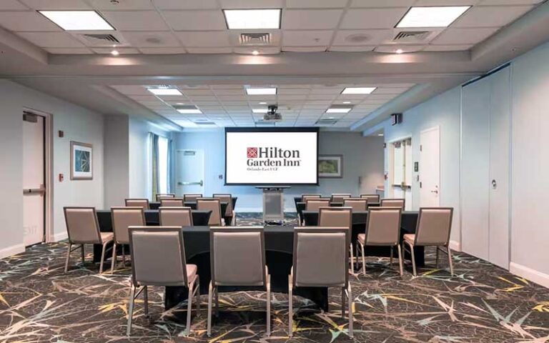 meeting space with screen display and seating at hilton garden inn orlando east ucf area