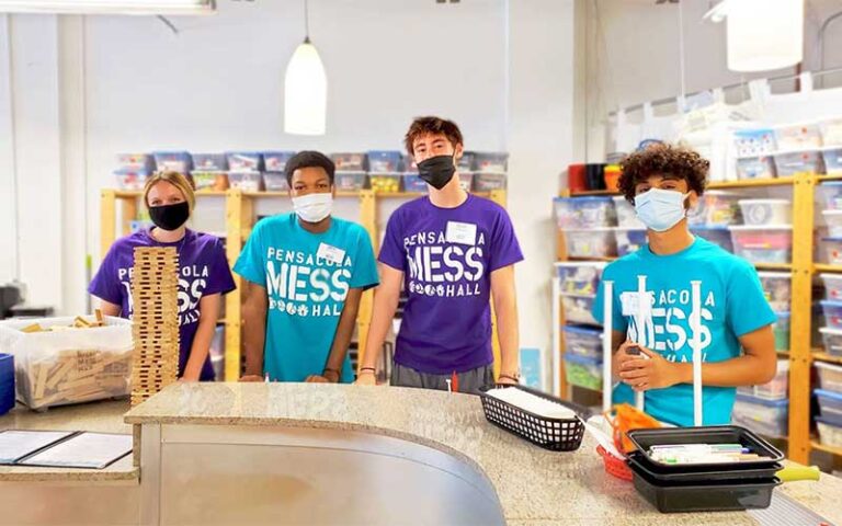 museum staff with branded shirts and masks at pensacola mess hall