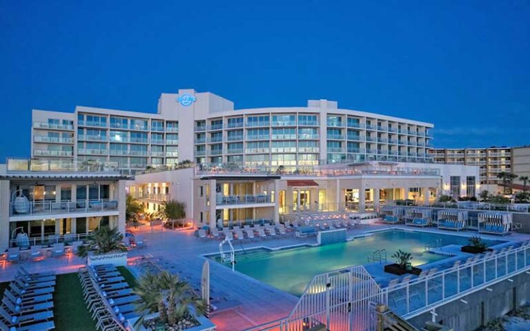 night exterior of lighted hotel with pool at hard rock hotel daytona beach