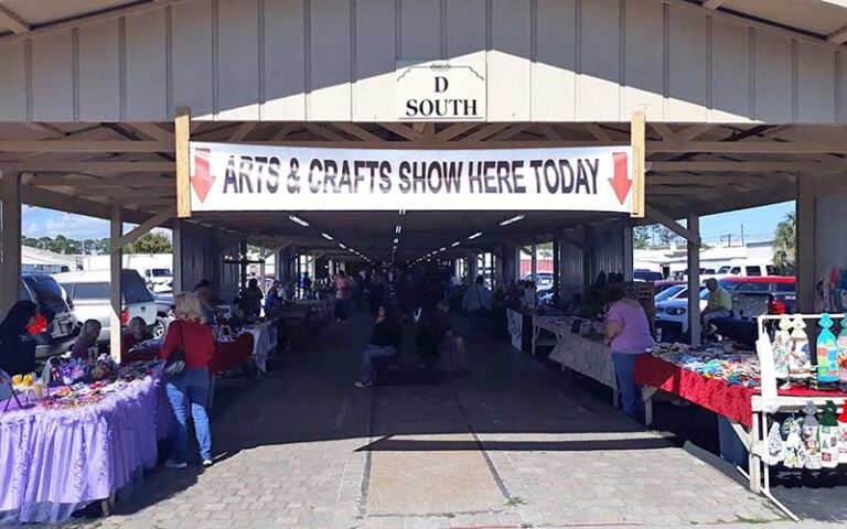 open pavilion with shoppers and arts crafts show sign at daytona flea farmers market daytona beach