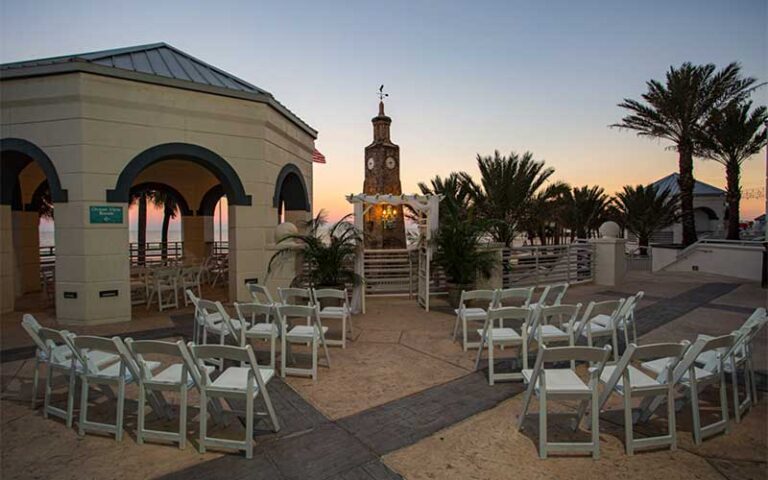 outdoor patio event space with clock tower at dusk at hilton daytona beach oceanfront resort
