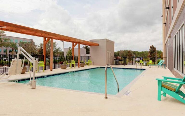 outdoor pool deck with pergola and ada lift at home2 suites by hilton orlando south park