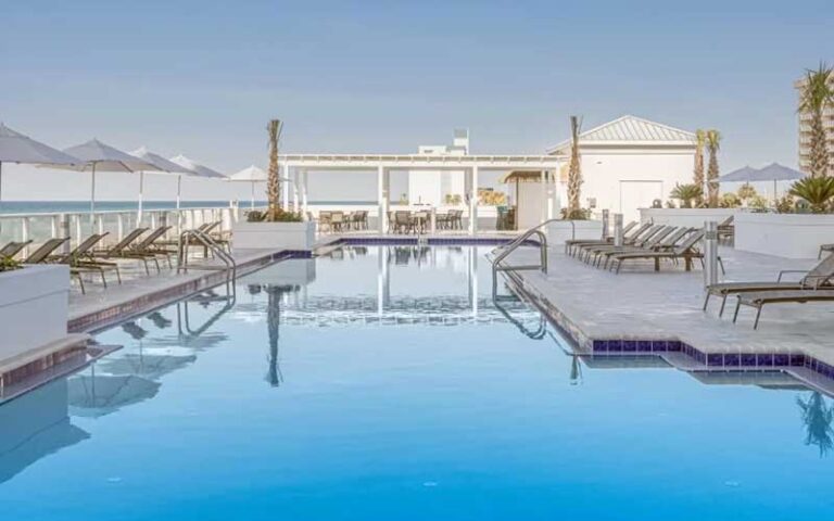 pool deck with blue water and cabanas at the pensacola beach resort