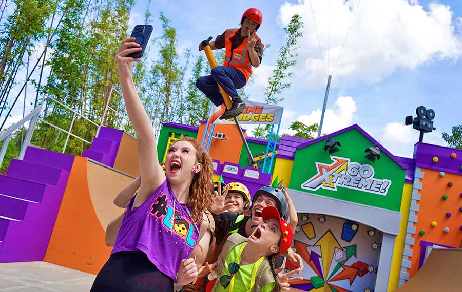 performers taking selfie with pogo stick guy go xtreme summer brick party at legoland florida resort