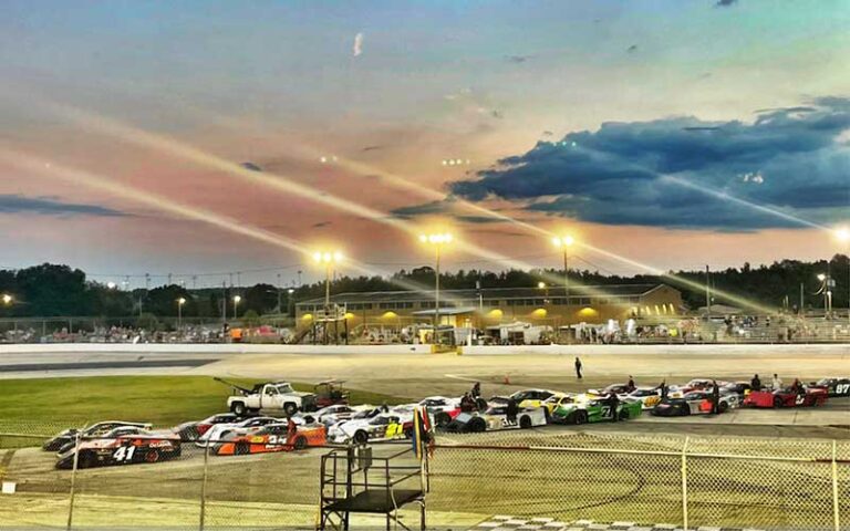 race track with cars and long exposure lights at night at auburndale speedway winter haven