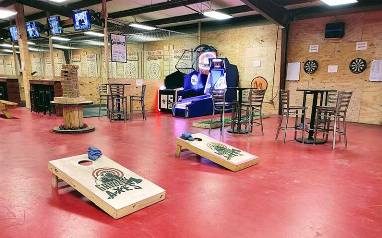 red floor area with axe targets cornhole and dart boards at grizzly axes pensacola