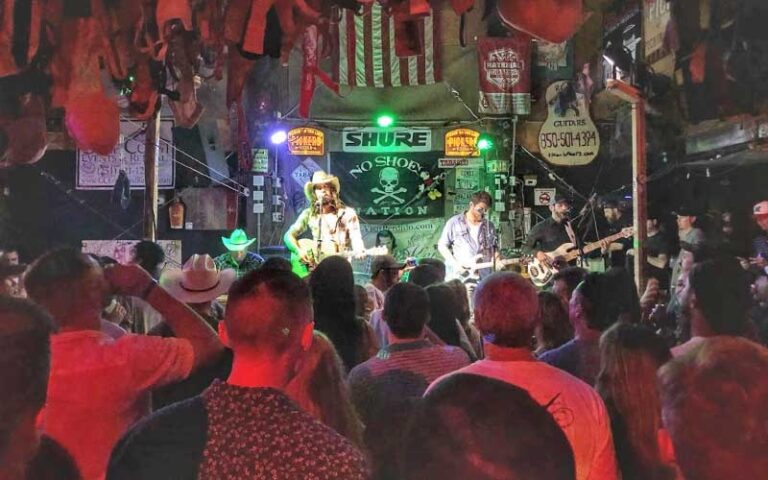 rock band performing on stage with crowd at flora bama pensacola