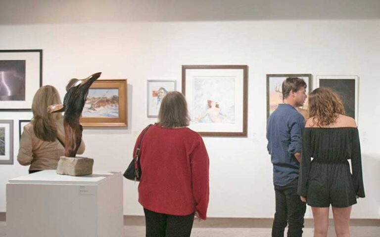 sculpture and hanging art with viewers at pensacola museum of art