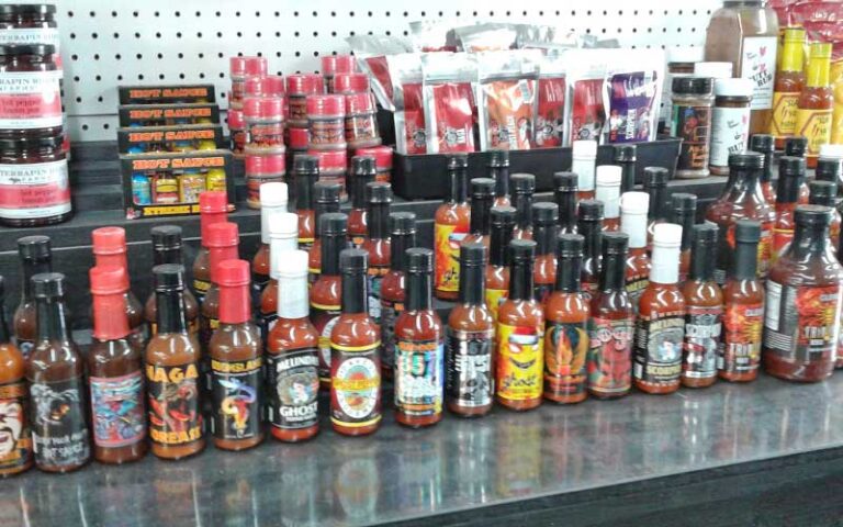 shop shelf with many hot sauce bottles at daytona flea farmers market daytona beach