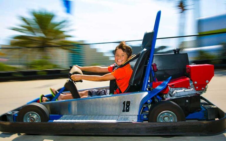 smiling boy driving go kart past at daytona lagoon daytona beach