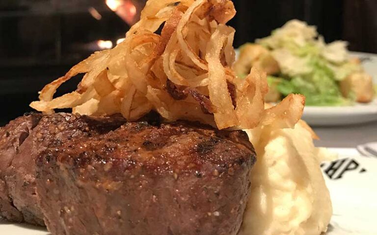 steak with onion straws and sides at hyde park prime steakhouse daytona beach