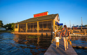 view from dock of restaurant with sunset light and mom and kid walking at harborside winter haven
