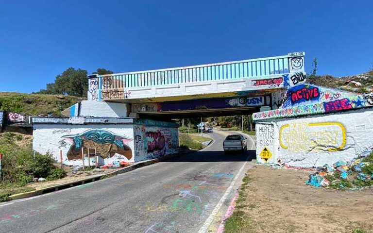 whitewashed railroad underpass with baby yoda at graffiti bridge pensacola