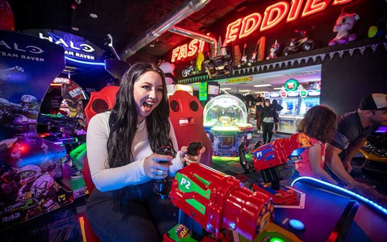 young lady playing shooter game in arcade at fast eddies fun center pensacola