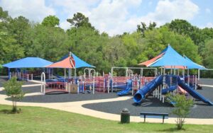 aerial view of large red and blue playground area with slides and canopies at tom brown park tallahassee
