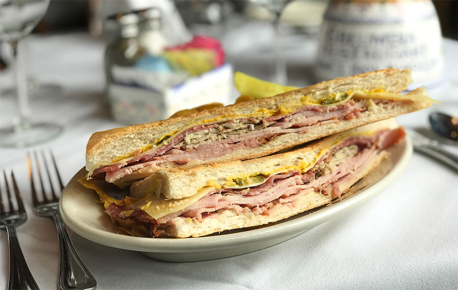 cuban sandwich on plate with table setting at columbia restaurant ybor city tampa